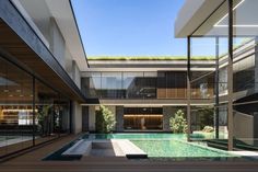 an indoor swimming pool in the middle of a building with glass walls and stairs leading up to it