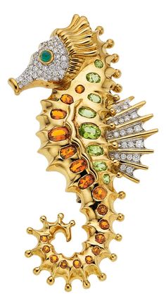 a gold seahorse brooch with multi - colored stones