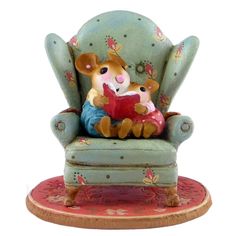 a small figurine sitting on top of a chair with a baby in it's lap