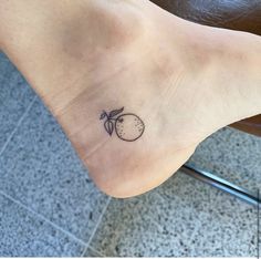 a small tattoo on the foot of a woman's foot with an apple in it