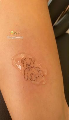 a small teddy bear drawn on the side of a woman's leg with clear plastic