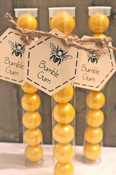 some yellow candies are in glass vases with tags on the top, and one is labeled bumble gum