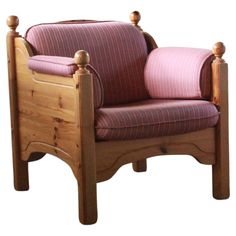 a wooden chair with pink and red striped upholstered fabric on the armrests