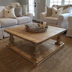 a living room with couches, chairs and a coffee table in the middle of it