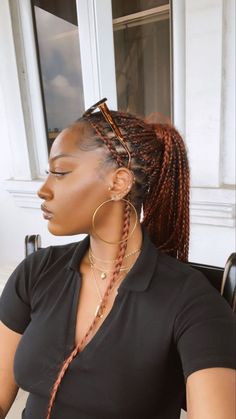 a woman sitting at a table with her hair in braids