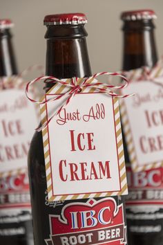 three bottles of ice cream sitting on top of a table with tags attached to them