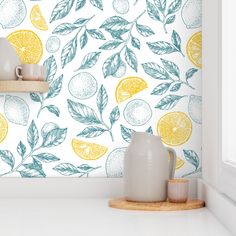 a wall with lemons and leaves painted on it in blue, yellow and white