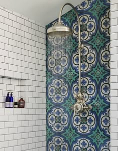 a shower head and hand held shower faucet in front of a tiled wall