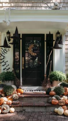 a front porch decorated for halloween with pumpkins and gourds