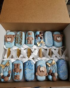 a box filled with blue decorated cookies in the shape of teddy bears and other items