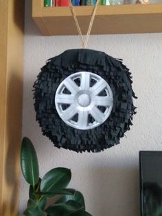 a car tire hanging from a shelf next to a potted plant and bookshelf