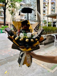 a person holding a bouquet of flowers in front of a building