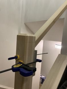 two screwdrivers are attached to the side of a wooden post in an unfinished room