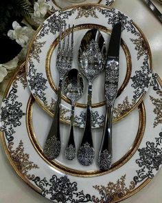 silver and gold place setting with flowers in the background