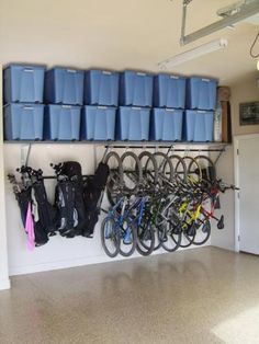 there are many blue bins on the wall with bicycles hanging from it's hooks