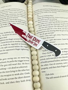 a bookmark with a knife on top of an open book