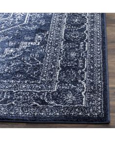 a blue rug with an ornate design on the top and bottom, sitting on a wooden floor