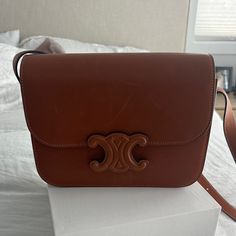 Brand New And Never Worn Authentic Celine Natural Calfskin Medium Triomphe In Tan. Features And Adjustable Strap Comes With Box And Dust Bag. Absolutely Stunning! No Longer Sell This With The Tan Closure Retails $4300 Luxury Brown Flap Bag, Luxury Tan Flap Shoulder Bag, Luxury Tan Shoulder Bag With Detachable Strap, Luxury Tan Flap Bag With Top Handle, Tan Luxury Flap Bag, Luxury Tan Crossbody Shoulder Bag, Designer Tan Shoulder Bag, Luxury Calf Leather Rectangular Shoulder Bag, Luxury Tan Crossbody Flap Bag