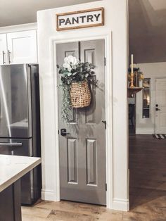 a door with a basket hanging on the front and side of it, next to a refrigerator