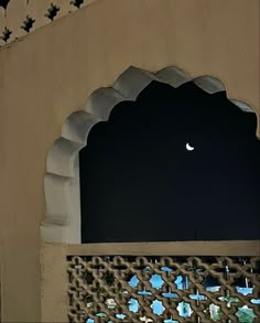 the moon is seen through an arched window