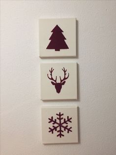 three square tiles with different designs on them, one has a deer head and the other is a snowflake