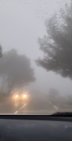 the sun is shining through the clouds in the distance as seen from inside a car