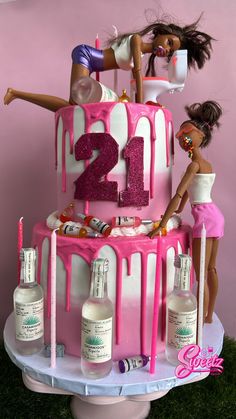 two barbie dolls are on top of a cake with pink icing and the number twenty