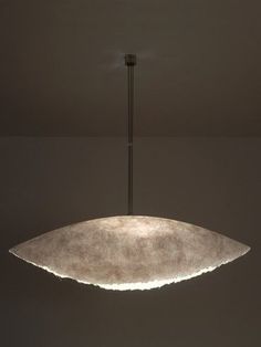 a light fixture hanging from the ceiling in a dark room with no one around it