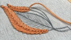 an orange piece of yarn sitting on top of a table