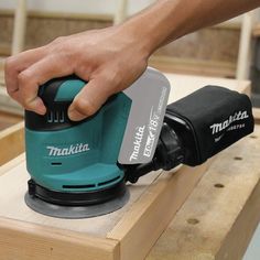 a person using a sander on top of a piece of plywood planks