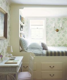 a bedroom with two beds and a desk in the corner, next to a window