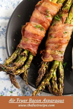 bacon wrapped asparagus on a black plate