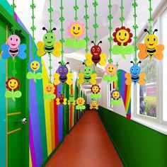 the hallway is decorated with lots of colorful decorations and hanging paper flowers on strings that are hung from the ceiling