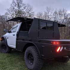 an off road vehicle parked in the grass with its roof open and lights on at night