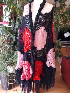 a crocheted shawl is displayed on a mannequin