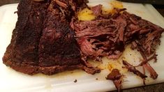 a large piece of meat sitting on top of a cutting board next to a knife