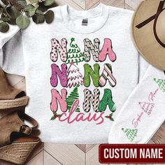 Personalized  Nana Claus T-Shirt, Custom Christmas Grandkid Name Sweatshirt, Merry And Bright Hoodie, Coquette Bow Xmas Tee, Gift For Grandma The Standard T-Shirt, personalized to suit your individual style, serves as the perfect medium for self-expression. Made from 100% preshrunk cotton, this timeless short-sleeve tee not only ensures comfort but also offers ample opportunities for print-on-demand customization. Whether you seek to showcase your creativity, promote your brand, or commemorate a Name Sweatshirt, Xmas Tees, Gift For Grandma, Coquette Bow, Printing Labels, Custom Christmas, Grandma Gifts, Individual Style, Merry And Bright