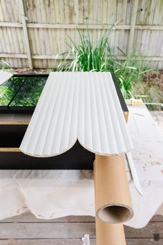 a piece of cardboard sitting on top of a table next to a potted plant