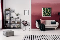 a modern living room with red walls and white flooring, black accents and furniture