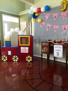 a birthday party with balloons and decorations on the wall, including an old fashioned train