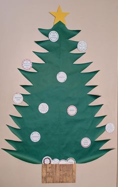 a christmas tree made out of green paper with white and gold stars on it's top