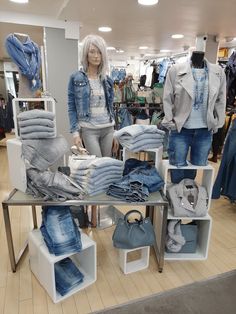 a display in a clothing store filled with lots of blue jeans and denim jackets on mannequins