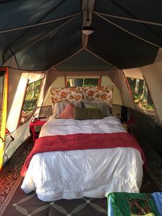 the inside of a tent with a bed and pillows