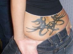 a woman's stomach with tattoos on it, showing the lower part of her body