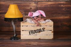 a baby wearing glasses and bunny ears sitting in a crate with the word fragile on it