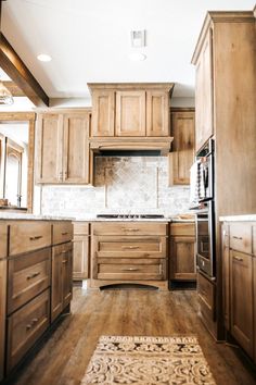 a kitchen with wooden cabinets and an area rug