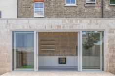 an empty room in front of a brick building with glass doors on the outside wall