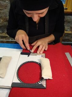 a woman cutting fabric with scissors on a table