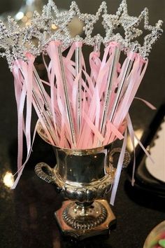 a vase filled with pink and silver straws on top of a table