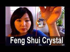 a woman holding up a crystal ball in front of her face with the words feng shui crystal